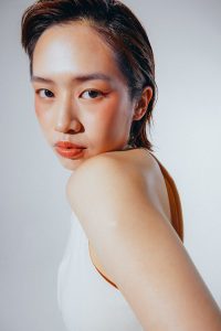 a woman in a white tank top posing for a picture