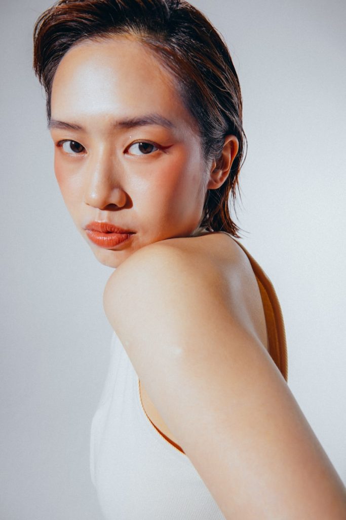 a woman in a white tank top posing for a picture