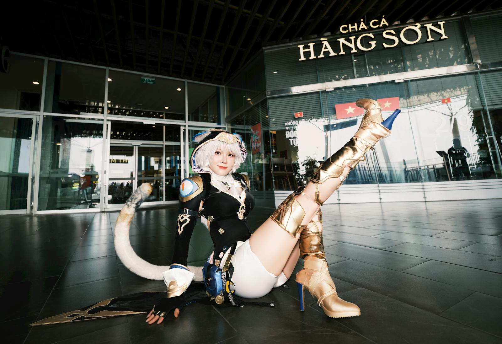 Cosplayer in detailed outfit poses at the entrance of Cha Ca Hang Son restaurant.