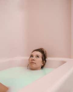 An adult woman enjoys a peaceful moment while relaxing in a soothing milk bath.