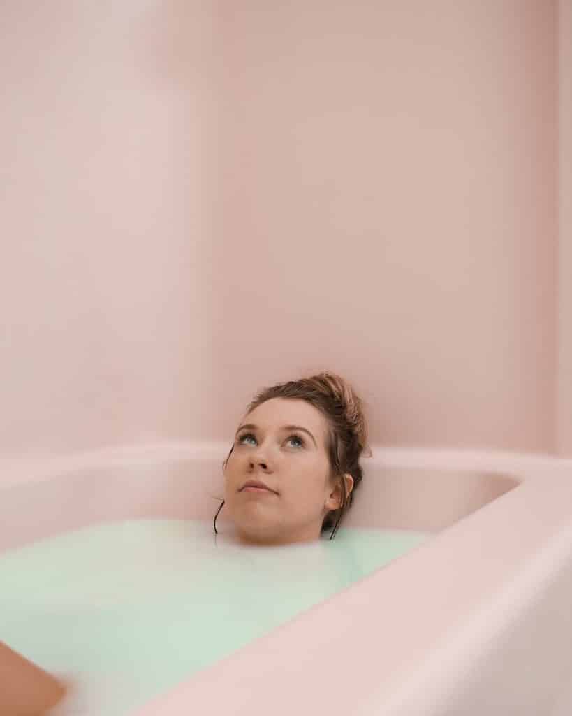 An adult woman enjoys a peaceful moment while relaxing in a soothing milk bath.