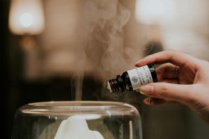 person holding black and white labeled essential oil bottle