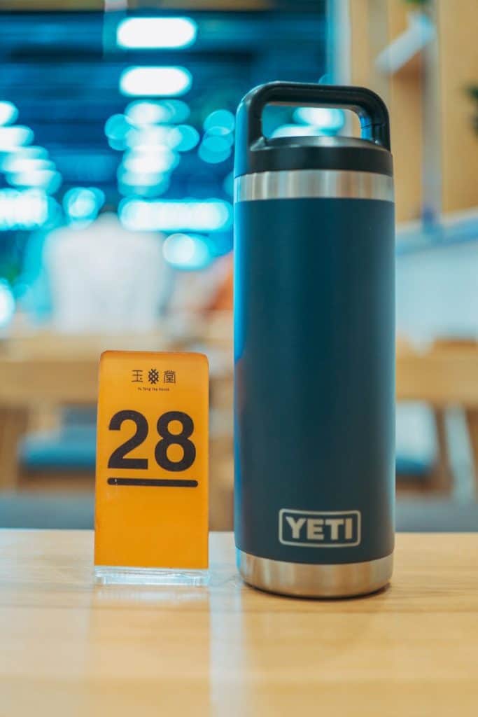 Blue Yeti tumbler on a table alongside a number 28 card in a blurred indoor setting.