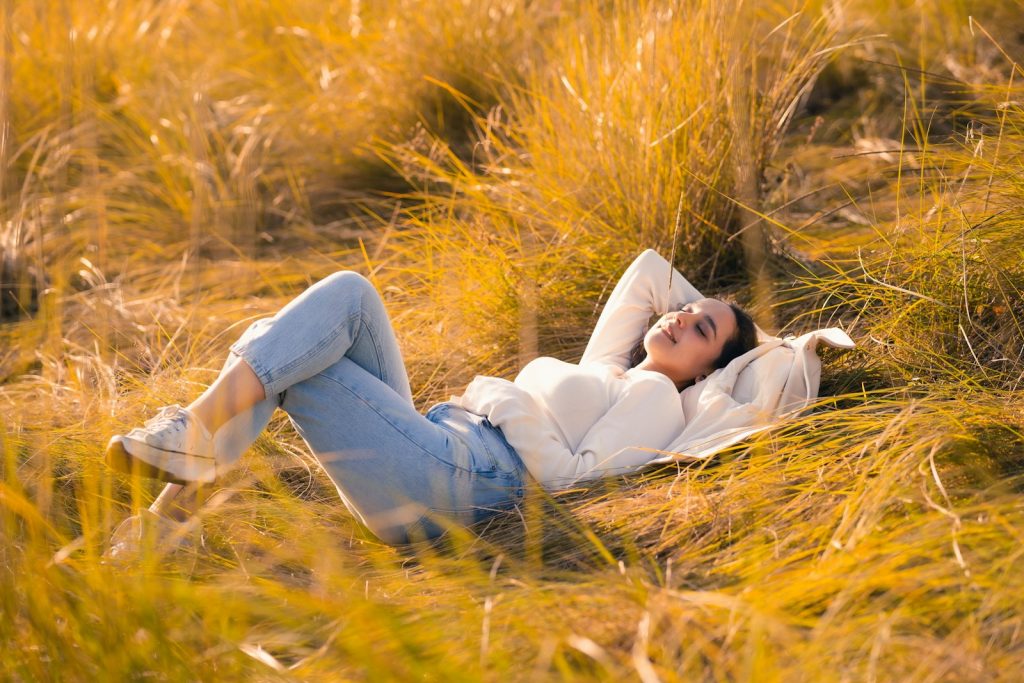 A woman laying in a field of tall grass