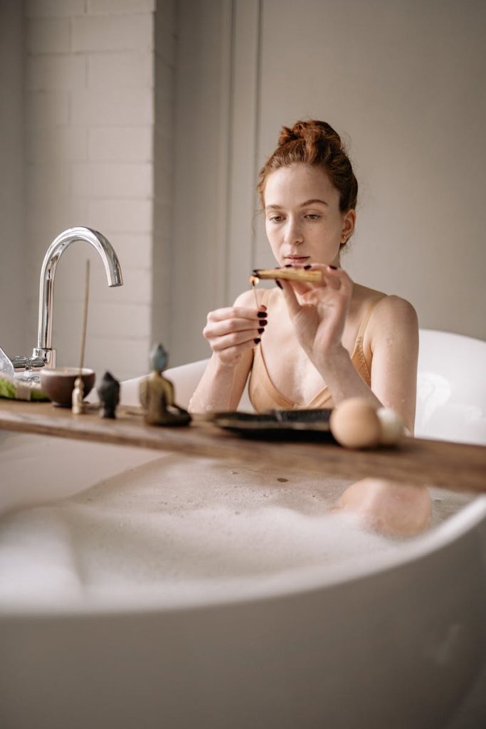 Woman enjoying a tranquil bath ritual with a focus on relaxation and self-care.