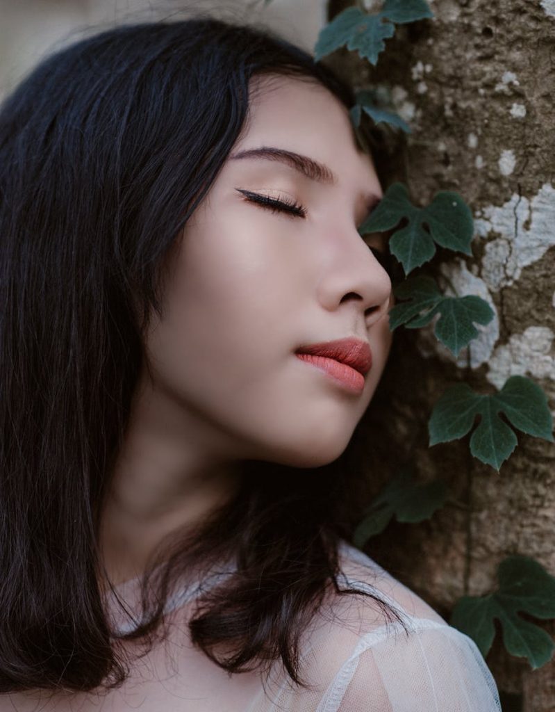 Soul Healing: A Complete Guide to Deep Emotional Recovery: A serene portrait of a young woman peacefully posing against a tree, surrounded by greenery.