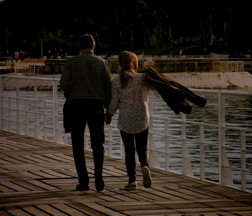 man and woman walking on wooden dock during daytime