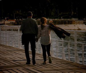 man and woman walking on wooden dock during daytime